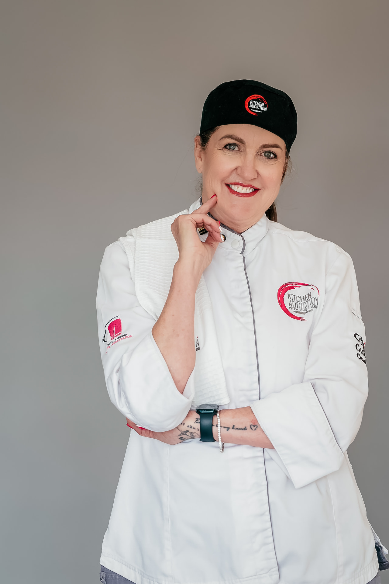 Chef Anni smiling in her white chef jacket and Kitchen Addiction cap